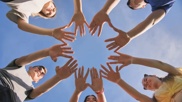 Friends make a circle shape from the palms of their hands