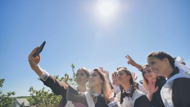 Happy high school graduates take a selfie on a sunny day