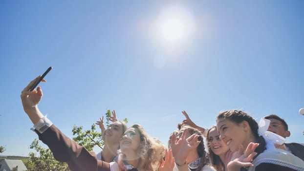 Happy high school graduates take a selfie on a sunny day