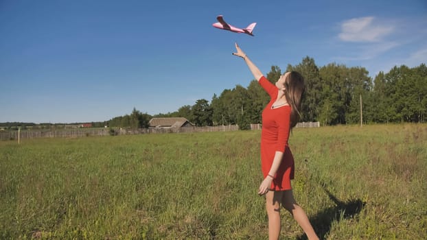 A girl launches a toy paralon airplane into the sky