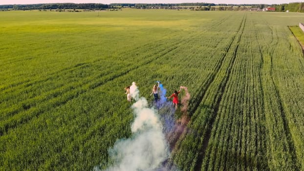 Happy friendly friends run across the field with toy planes that emit colored smoke
