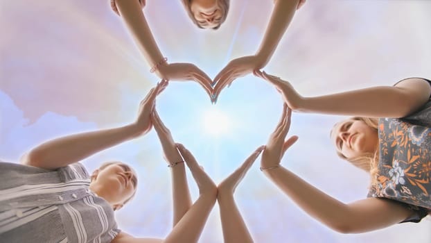 A group of youth makes a heart shape out of their hands