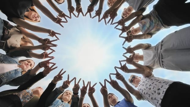 A group of friends make a circle out of their fingers. The concept of unity