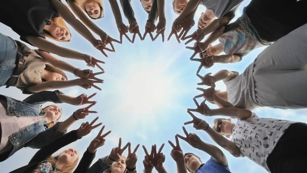 A group of friends make a circle out of their fingers. The concept of unity