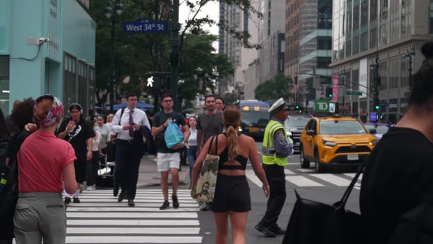 New York City, United States - 29 Aug 2023: Manhattan Midtown 34 street. Herald Square, Broadway, Sixth 6 Americas avenue, USA. People, zebra crosswalk. Road traffic Control Police guard, NYPD flagger