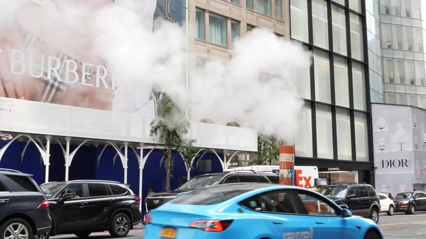 New York City, United States - 11 Sept 2023: Manhattan Midtown street, Fifth 5 avenue. American urban scene, USA. People pedestrians. Boutique stores for luxury fashion shopping. Hot steam smoke stack