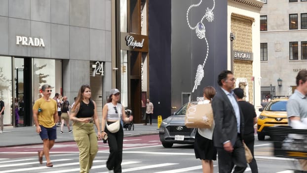 New York City, United States - 11 Sept 2023: Manhattan Midtown street, Fifth 5 avenue. American urban road car traffic, crossroad intersection. Yellow taxi in USA. People pedestrians. Shopping stores.