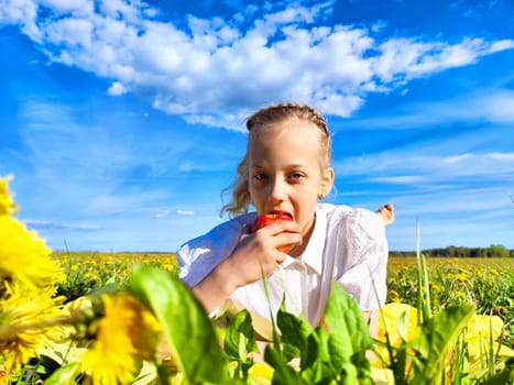 A young girl with braided hair bites into a fresh apple, surrounded by vibrant flowers and a clear blue sky.