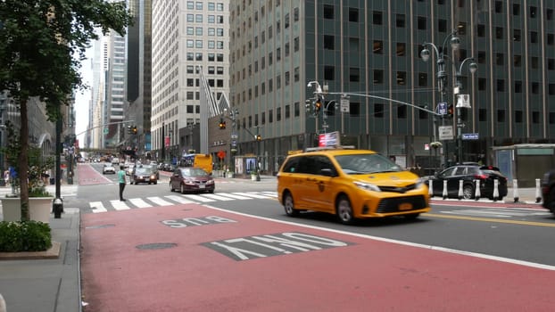 New York City, United States - 4 Sept 2023: Manhattan Midtown East 42 street, 3 avenue crossroad intersection. Urban road car traffic in USA. People pedestrians on zebra. Yellow taxi cab, red bus lane