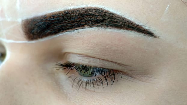 Permanent makeup. Applying permanent make up on eyebrows - eyebrow tattoo