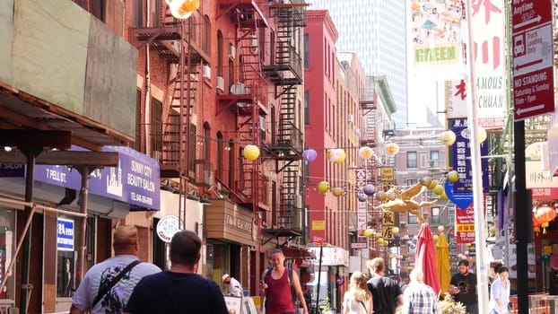 New York City, United States - 14 Sept 2023: Manhattan Chinatown Pell street. Chinese culture, ethnic district architecture, USA. Red brick buildings, round paper lanterns and hieroglyph signs. People