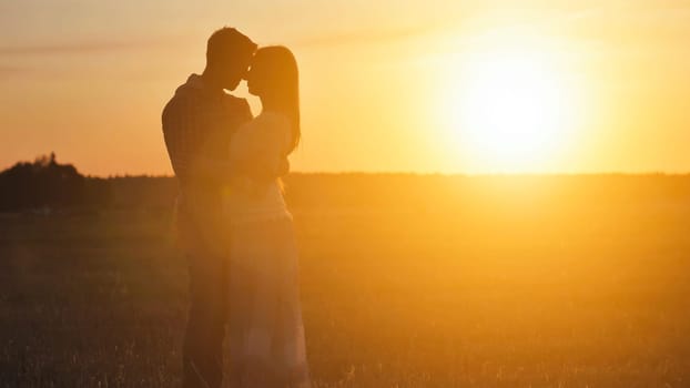 Silhouette of a loving couple hugging on a sunset background