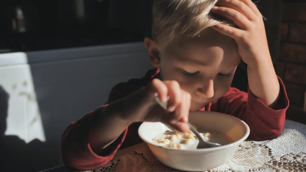 The child eats milk pasta soup for breakfast