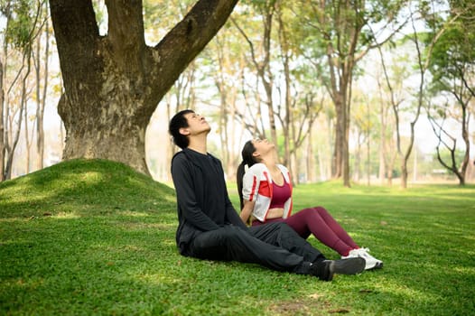 Calm asian couple resting after finishing their exercise routine.