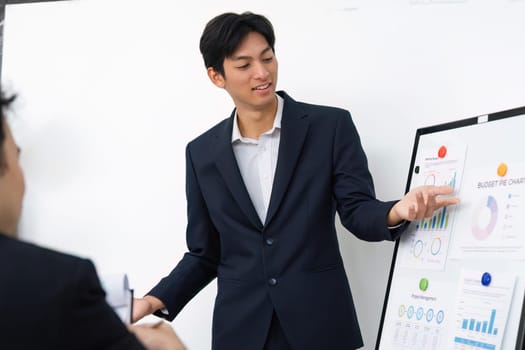 A confident presenter engages others in a discussion about financial metrics, using visual displays to clarify and enhance understanding.
