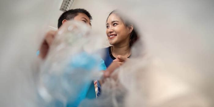 Through a lens of plastic waste, a young boy and a smiling instructor connect over the importance of recycling, embodying the spirit of eco-awareness.