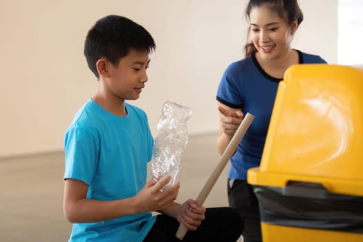 In a community initiative, a young boy discovers the importance of recycling, assisted by a woman who guides him in proper disposal techniques.