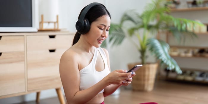 Enjoying the moment, a woman listens to a guided meditation on her phone, encouraging mindfulness and relaxation in her wellness routine at home.