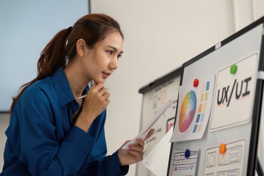A focused designer analyzes critical UX UI design elements presented on a board, showcasing an innovative approach to user interface development.