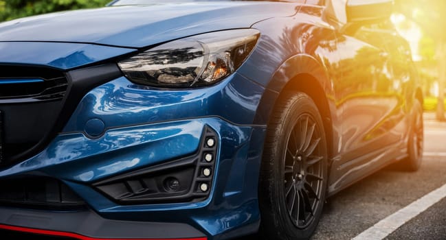 Luxury blue car's modern xenon headlight lamp. Shiny chrome design safety technology for night driving. Clean reflective sedan headlight in car industry. Detail on one of the LED car headlights