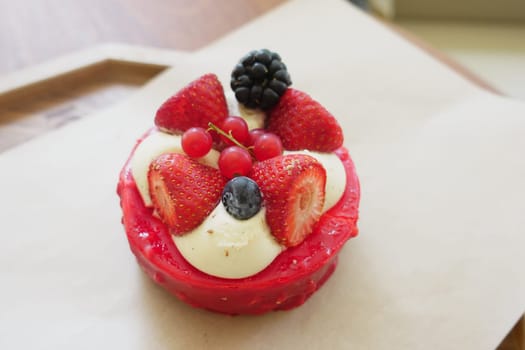 Delicious tart features fresh strawberries, blackberries, and cream in daylight.