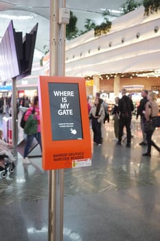 People crowd around an information kiosk searching for their flight gates.