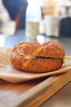 A delicious bagel on a wooden tray with toppings for breakfast.