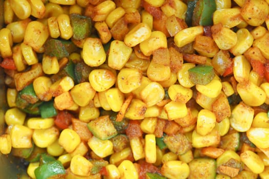 Mixed corn and diced bell peppers cooked with spices in a bowl.