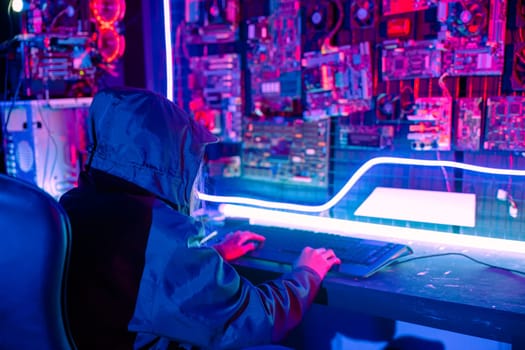 Woman hacker. Asian woman wearing hood is typing keyboard for coding hacking programming system. room is dimly lit. possibly typing or browsing internet, Hacker in neon light, Female gamer play game