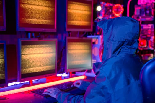 Woman hacker wear hood sit front computer typing on keyboard hacking servers in neon light, Gamer woman streaming game online dark room, Female hacker breaks into data center, Blockchain cyberattack