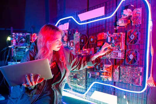 Cyber security. Software engineer holding laptop computer at data center checking hardware, Hacker woman service in server room, check circuit board with many small components