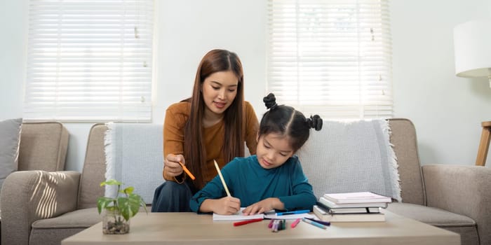 In a cozy living room, a mother helps her daughter with her schoolwork, creating a joyful and supportive study environment.