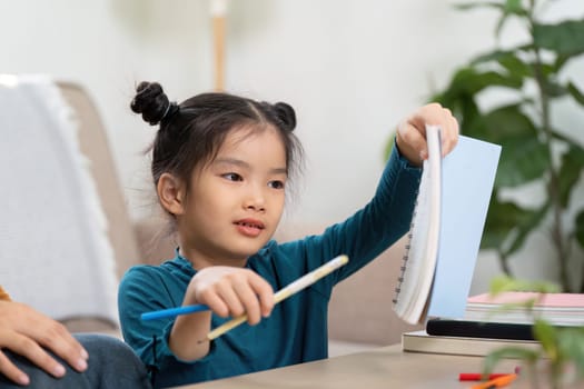 In a cozy home setting, a girl shares her artwork and writings with her caregiver, showcasing her efforts and creativity.