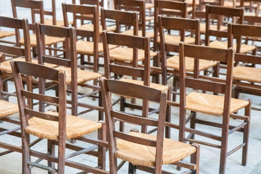 Rows of empty old wooden seats or chairs in the church, theatre or music concert, abstract pattern.