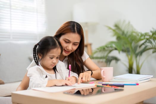An engaged mother sits with her daughter at a table filled with colorful stationery, guiding her through homework while fostering a bond over education.
