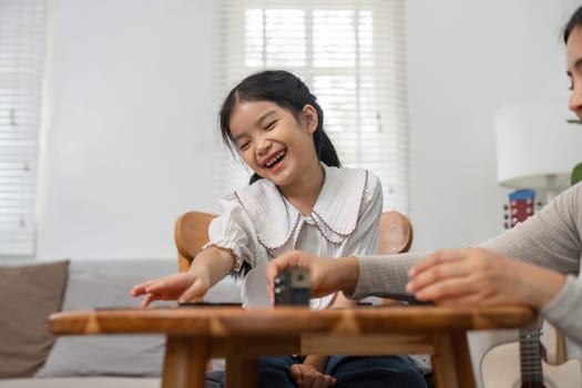 Amid laughter and joy, a girl shares a playful interaction with her mother, emphasizing the importance of family time through games.