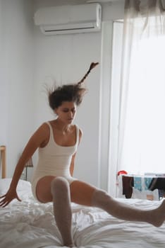 A whimsical morning scene with a girl playfully jumping on a bed, capturing the essence of youth and spontaneity.