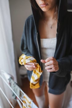 A person dressed casually in a comfy hoodie while holding a colorful cloth, creating a warm and inviting homey vibe
