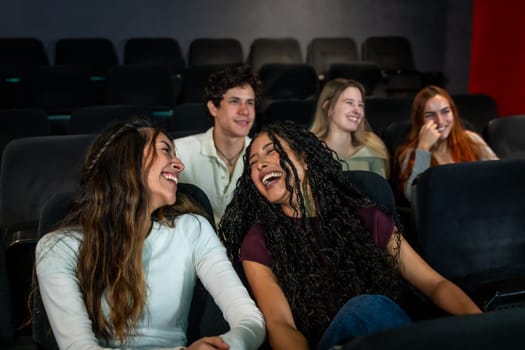 Friends enjoying laughter together while watching a comedy film at the cinema, sharing moments of joy and fun in a vibrant atmosphere