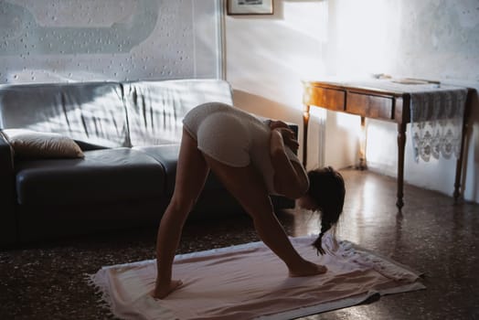 A beautifully serene yoga practice, held in a cozy and sunlit living space, showcasing flexibility and tranquility