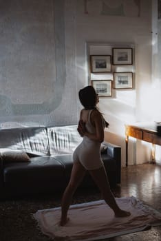 A graceful figure diligently practicing yoga in a serene indoor setting, softly illuminated by gentle sunlight