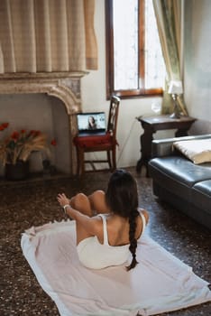 A woman engages in a fitness routine at home, showcasing dedication and wellness through online training.