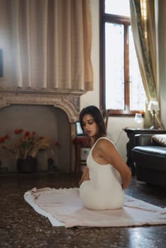 A serene and calm scene of a woman gracefully practicing yoga in a cozy, sunlit and comfortable living room