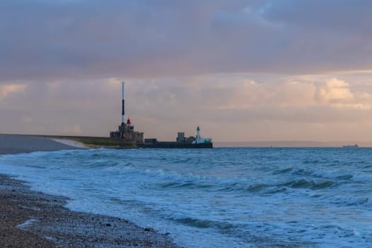 Le Havre, France, February 26, 2025: A ship departs from the port of Le Havre, goes into the open sea of the English Channel under a moody Norman sky at evening.