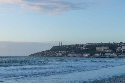 Le Havre, France, February 26, 2025: The high cliffs of Normandy rise above the sea in Le Havre, glowing with the last light of sunset as twilight wraps the coastline in soft, fading colors