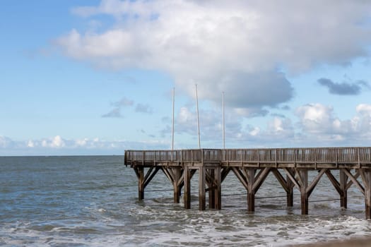 Sainte-Adresse, France - February 27, 2025: A wooden pontoon stretches into the English Channel from Sainte-Adresse, near Le Havre, under a cool February sky along the coast of Seine-Maritime, France