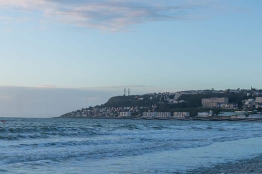 Le Havre, France, February 26, 2025: The high cliffs of Normandy rise above the sea in Le Havre, glowing with the last light of sunset as twilight wraps the coastline in soft, fading colors