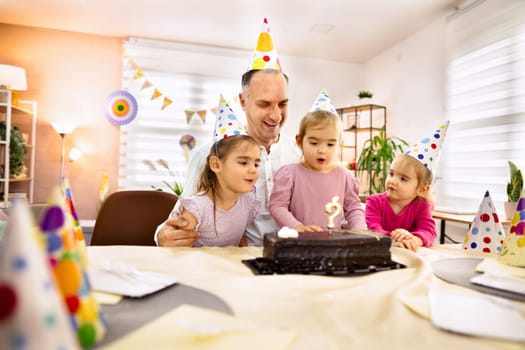 Laughter fills the room as children admire a delicious birthday cake.