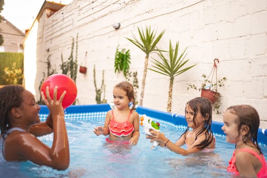 Four kids splash and play together in a vibrant outdoor pool.