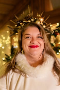A woman with long blonde hair wears a white fur coat and a crown of golden ornaments. She smiles at the camera.